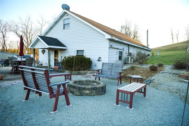 rear view of property with a fire pit