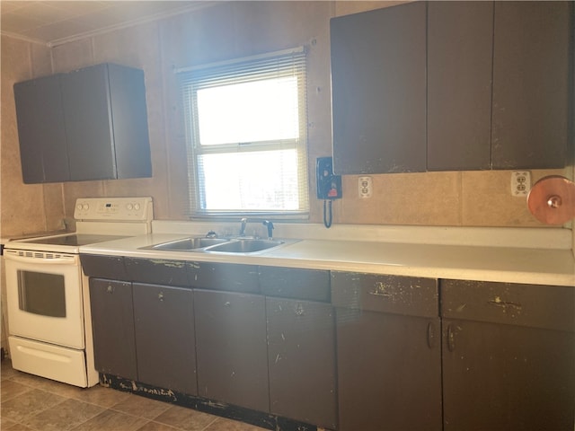 kitchen featuring white range with electric cooktop, light tile flooring, and sink