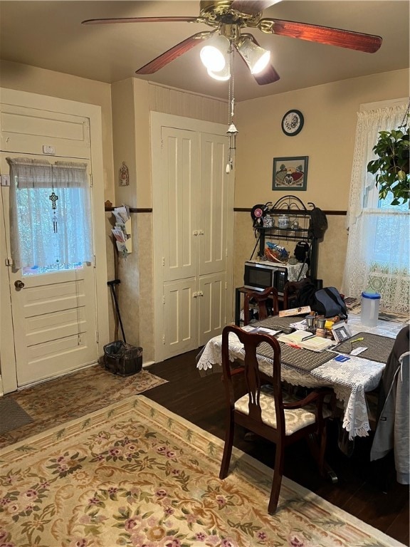 dining area featuring ceiling fan, dark wood-type flooring, and a wealth of natural light