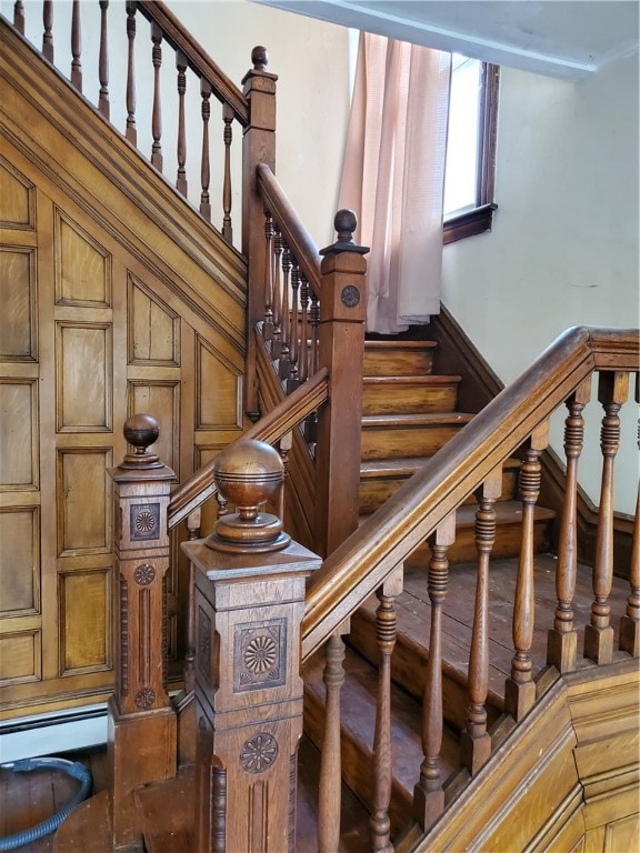 stairway featuring a baseboard heating unit