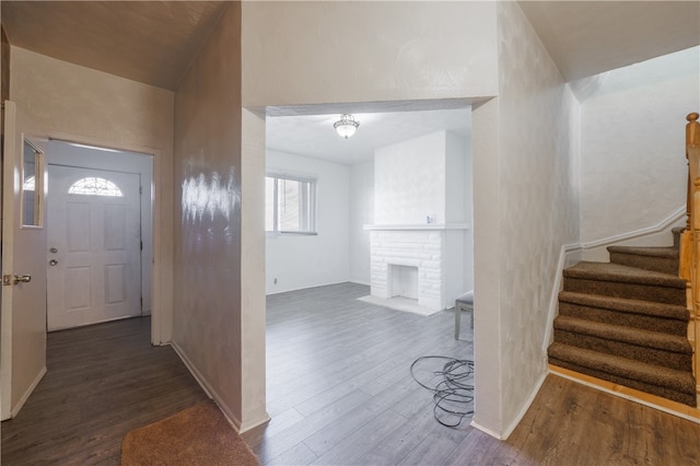 entrance foyer featuring dark hardwood / wood-style flooring and a brick fireplace