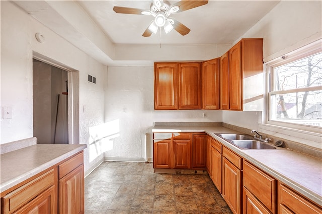 kitchen with ceiling fan, sink, and dark tile flooring