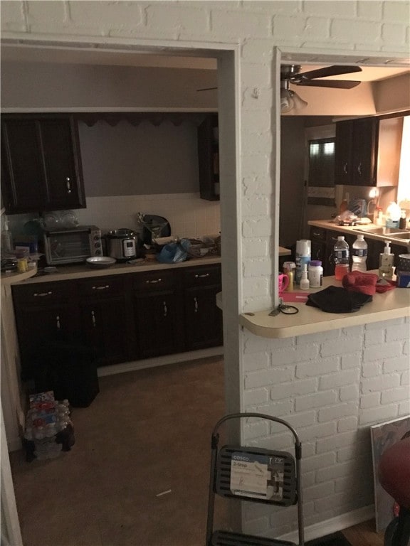 kitchen featuring ceiling fan and dark brown cabinetry