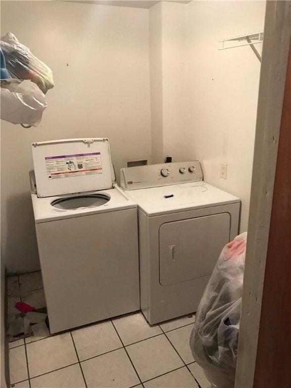 laundry area featuring light tile flooring and washer and clothes dryer