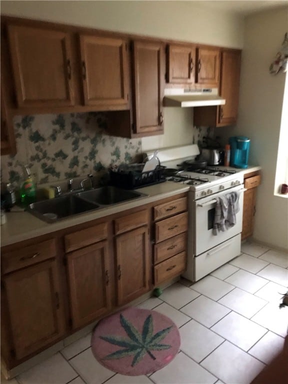 kitchen featuring light tile floors, sink, and gas range gas stove