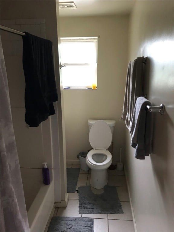 bathroom with toilet, shower / tub combo, and tile flooring