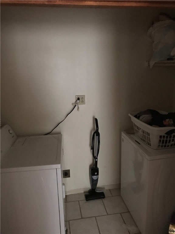 washroom featuring hookup for an electric dryer, washing machine and clothes dryer, and light tile flooring