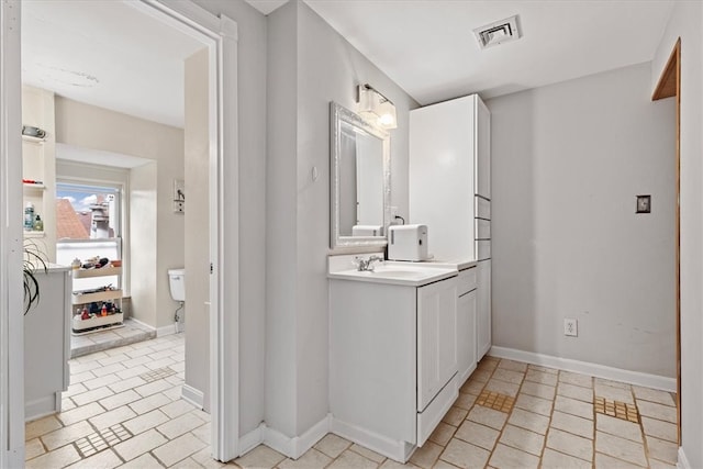 bathroom featuring vanity, tile floors, and toilet