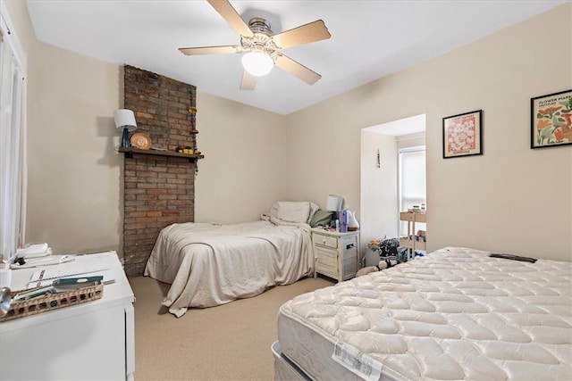 bedroom featuring ceiling fan, brick wall, and light carpet