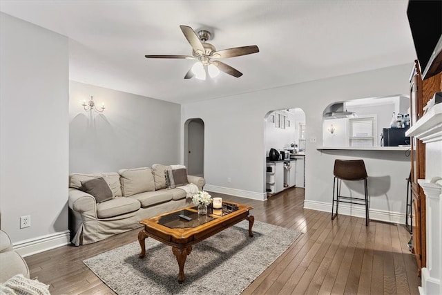 living room featuring ceiling fan and dark hardwood / wood-style floors