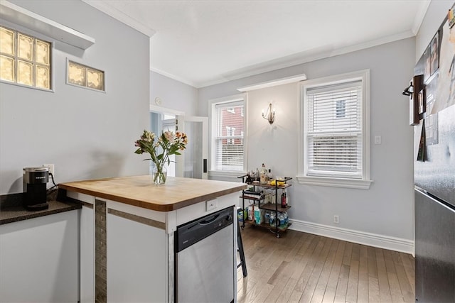 kitchen featuring dark hardwood / wood-style floors, ornamental molding, white cabinets, dishwasher, and wood counters