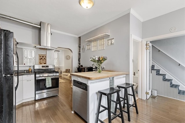 kitchen featuring white cabinets, appliances with stainless steel finishes, dark wood-type flooring, and exhaust hood