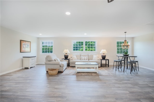 living room with light hardwood / wood-style floors, an inviting chandelier, and a wealth of natural light