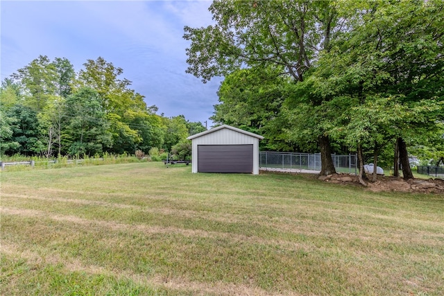 view of yard with a garage and an outbuilding