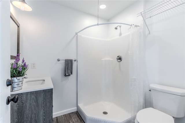 bathroom with curtained shower, vanity, hardwood / wood-style flooring, and toilet