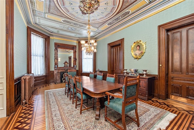 dining area with an inviting chandelier, a wealth of natural light, ornamental molding, and a tray ceiling