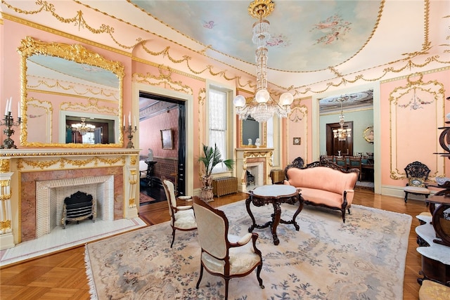 living area with an inviting chandelier, dark parquet floors, and ornamental molding