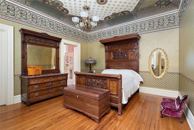 bedroom featuring an inviting chandelier and light wood-type flooring