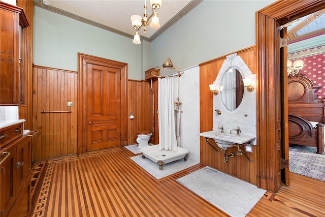 bathroom featuring wood-type flooring, toilet, vanity, and an inviting chandelier