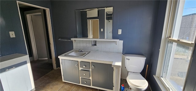 bathroom featuring toilet, tasteful backsplash, vanity, and tile flooring