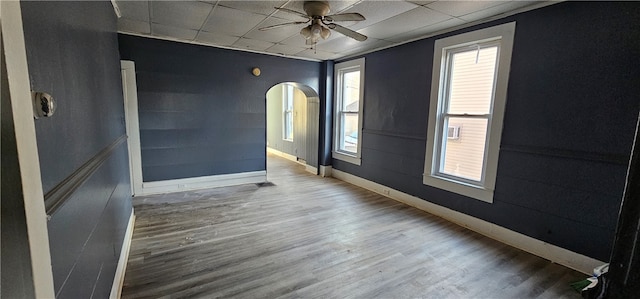 empty room featuring dark hardwood / wood-style flooring, ceiling fan, and a wealth of natural light