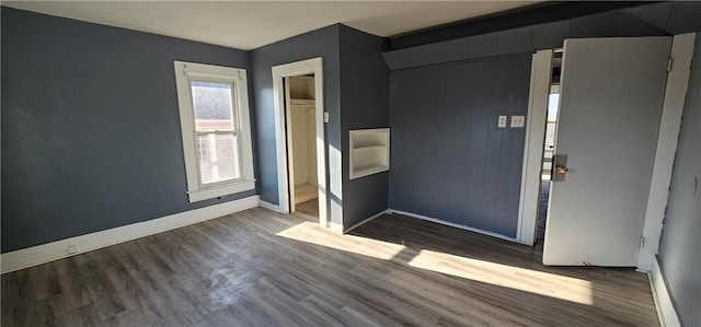 unfurnished bedroom with a closet and dark hardwood / wood-style flooring