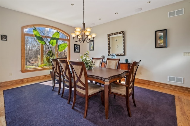 dining room featuring wood-type flooring and a chandelier