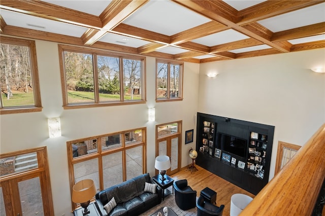 living room with coffered ceiling, hardwood / wood-style floors, and beam ceiling