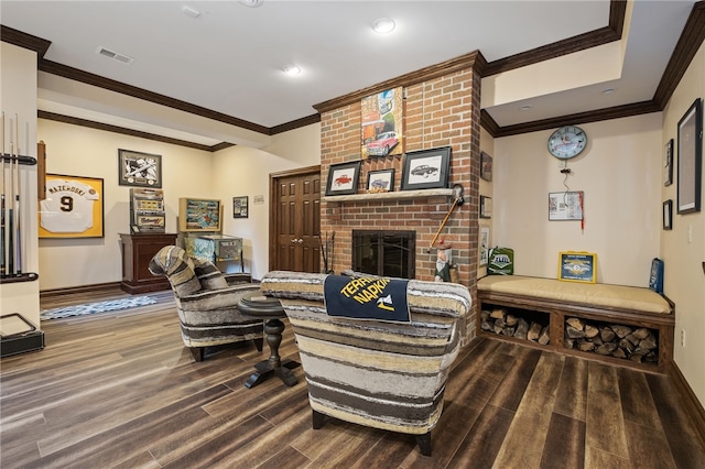 living room featuring hardwood / wood-style flooring, a fireplace, and crown molding