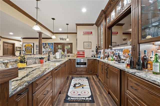 bar featuring ornamental molding, sink, decorative light fixtures, dark hardwood / wood-style floors, and ornate columns