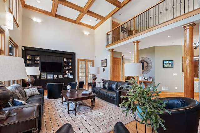 living room featuring decorative columns, a high ceiling, coffered ceiling, and beam ceiling