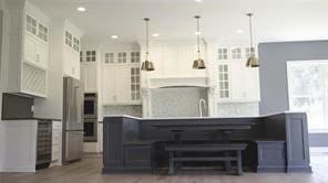 kitchen featuring a center island, hanging light fixtures, white cabinets, appliances with stainless steel finishes, and sink