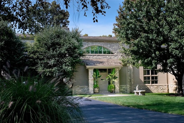 obstructed view of property with a front yard