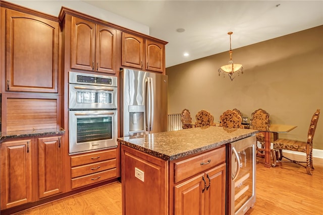 kitchen featuring decorative light fixtures, wine cooler, light hardwood / wood-style flooring, and appliances with stainless steel finishes