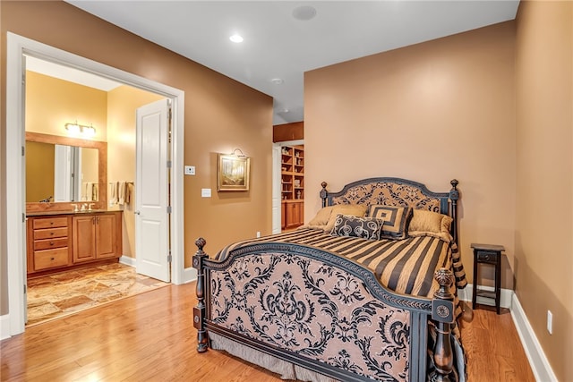 bedroom with sink, ensuite bath, and light tile floors