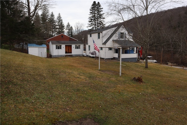 view of front of home featuring a front lawn and an outdoor structure