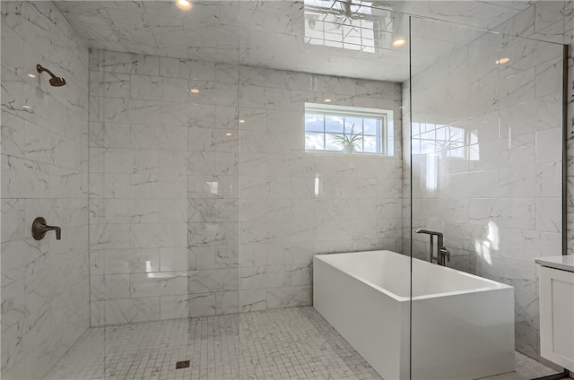 bathroom featuring shower with separate bathtub, vanity, and tile walls