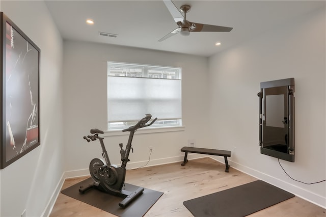 workout area featuring light wood-type flooring and ceiling fan