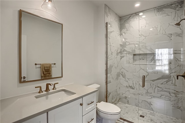 bathroom featuring a shower with door, toilet, and vanity