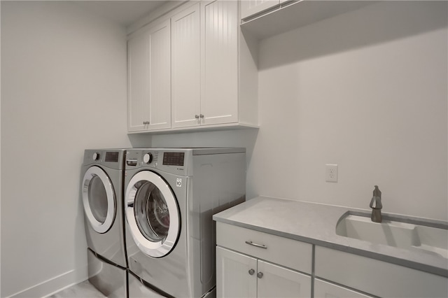 washroom featuring cabinets, washing machine and dryer, and sink