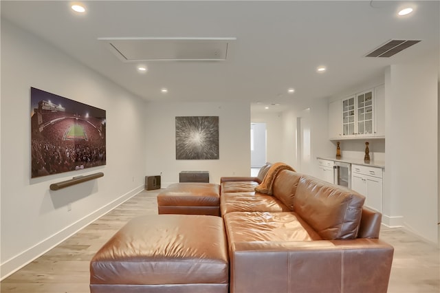 home theater with light hardwood / wood-style flooring and beverage cooler