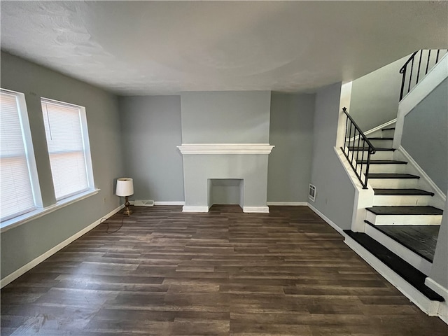 unfurnished living room with dark wood-type flooring