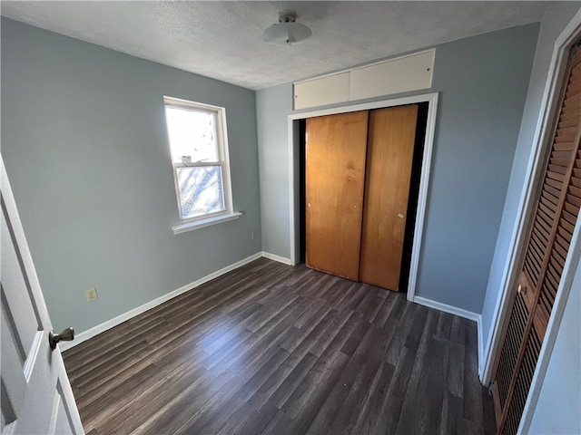 unfurnished bedroom featuring a closet, dark wood-type flooring, and a textured ceiling