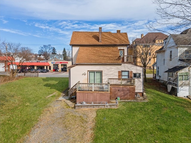 rear view of property with a yard and a wooden deck