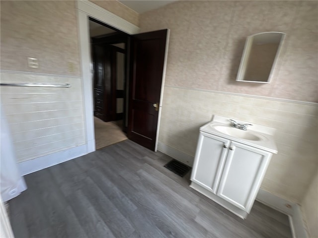 bathroom with vanity, tile walls, and hardwood / wood-style floors