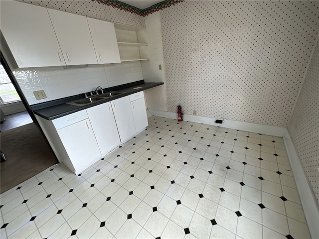 kitchen featuring tasteful backsplash, sink, and white cabinets