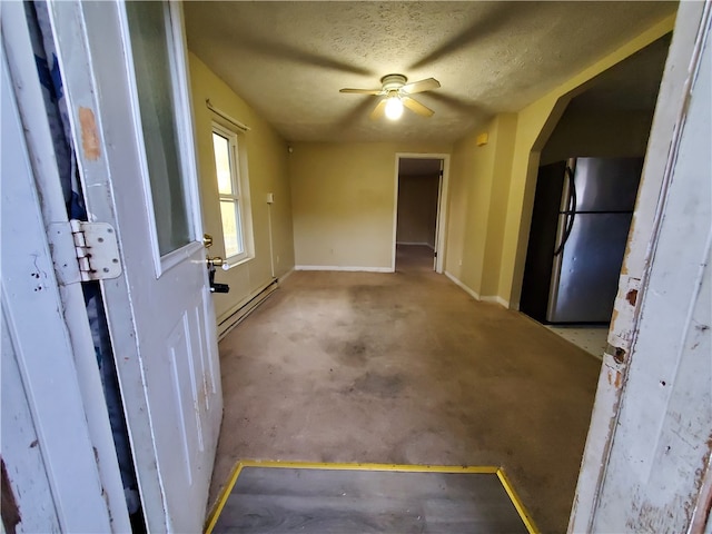 carpeted spare room featuring a baseboard heating unit, a textured ceiling, and ceiling fan