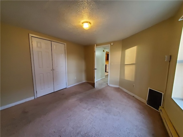 unfurnished bedroom with a closet, a baseboard radiator, and light colored carpet