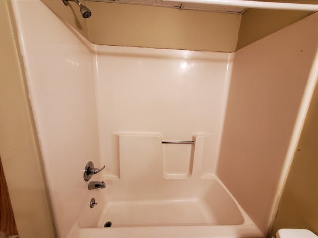 bathroom with shower / bathing tub combination and toilet