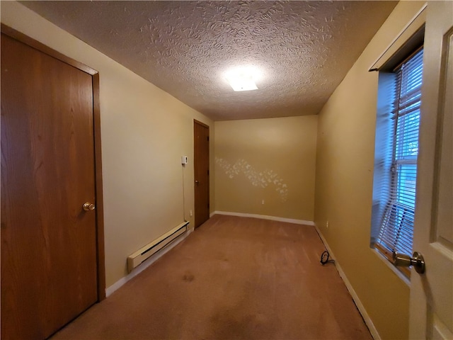 spare room with a textured ceiling, carpet floors, and baseboard heating